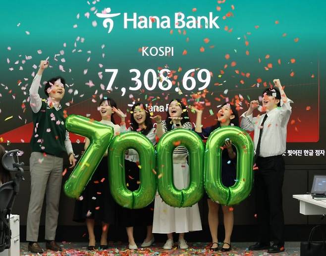 코스피가 7천을 돌파한 6일 서울 중구 하나은행 본점 딜링룸에서 직원들이 축하 세리모니를 하고 있다. 연합뉴스