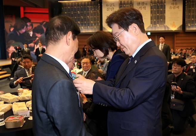 이재명 대통령과 김혜경 여사가 8일 오전 서울 중구 대한상공회의소에서 열린 어버이날 기념식에서 국민의 안전을 위해 봉사하다 순직한 소방·경찰 공무원 부모 11명의 가슴에 카네이션을 직접 달아주고 있다. 청와대사진기자단