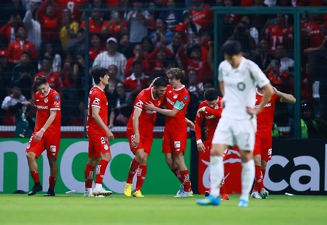 CONCACAF 챔피언스컵 - 준결승 2차전 - 톨루카 대 로스앤젤레스 FC - 에스타디오 네메시오 디에스, 톨루카, 멕시코 - 2026년 5월 7일. 톨루카의 파울리뉴가 네 번째 골을 넣은 후 동료들과 함께 기뻐하고 있고, 로스앤젤레스 FC의 손흥민은 실망한 표정을 짓고 있다. 로이터연합뉴스