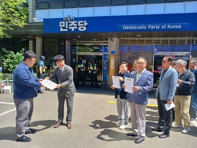 고양빛의연대 등 고양 시민단체 관계자들이 9일 여의도 더불어민주당 당사 앞에서 민주당 관계자에게 성명서를 전달하고 있다. 사진=고양빛의연대
