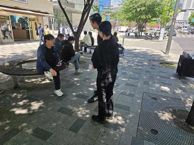 서울 중림동의 한 흡연구역에서 액상형 전자담배 브랜드 직원들이 연초 흡연자에게 제품 사용법을 설명하고 있다. 현장에서는 제품 시연과 함께 휴대용 담배꽁초 수거함도 제공됐다. 권용훈 기자