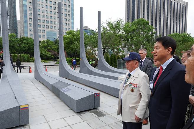 오세훈 국민의힘 서울시장 후보가 12일 서울 종로구 광화문광장에서 열린 ‘감사의 정원 준공식’에서 6.25 참전유공자와 석재 조형물을 보고 있다. 연합뉴스
