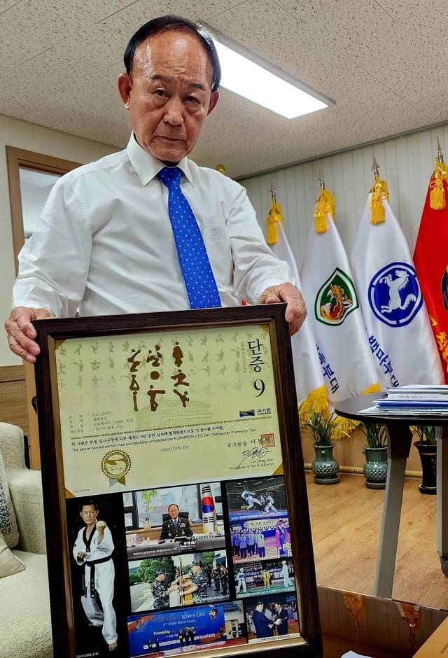 김길래 고엽제전우회장이 14일 서울 서초구 고엽제전우회관 집무실에서 62세에 딴 태권도 공인 9단 승단증과 군복무 시절 태권도 보급을 위해 활동한 사진 등이 담긴 액자를 들어보이고 있다. 사진=정충신 선임기자