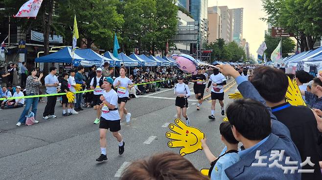 16일 오후 5시 40분쯤 광주 동구 금남로에서 결승선을 코앞에 앞둔 'RUN 5·18' 참가자들을 시민들이 응원하고 있다. 한아름 기자