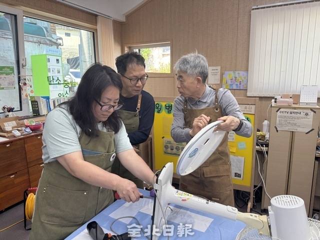 지난 15일 전주시 탄소중립완산마을에서 진행된 선풍기 상담소에서 시민들이 강사(오른쪽)의 설명을 들으며 고장난 선풍기를 직접 수리하고 있다. 이상구 수습기자