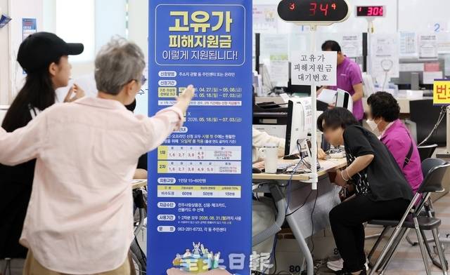 18일 전주 서신동 주민센터에서 직원이 시민에게 고유가 피해 지원금 신청방법을 안내 중이다. /조현욱 기자