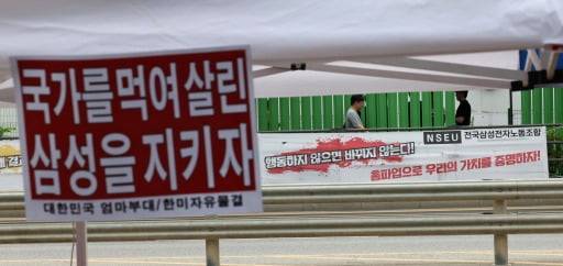 삼성전자 노사 사후조정 이틀째인 19일 삼성전자 평택캠퍼스 주변에 삼성전자 노조의 파업 관련 현수막(오른쪽)과 파업을 반대하는 시민단체의 손팻말이 걸려 있다. 삼성전자 노사는 이날 오전 10시부터 정부세종청사 중앙노동위원회에서 비공개로 2차 사후조정 회의를 이어간다. 노조는 오는 21일부터 내달 7일까지 18일간 약 5만명이 참여하는 총파업을 진행하겠다고 예고한 바 있다. 평택=이솔 기자