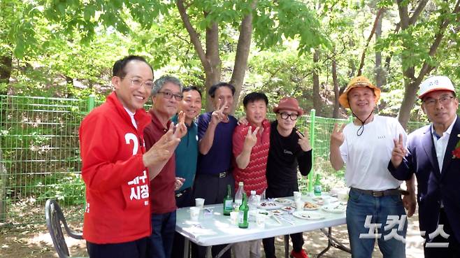 국민의힘 추경호 대구시장 후보가 17일 대구 수성구 영남공업고등학교 총동창회 체육대회를 찾자 참석자들이 자리에서 일어나 환호하며 기호 2번을 뜻하는 손가락 브이(V)를 그려보이고 있다. 박수연 기자