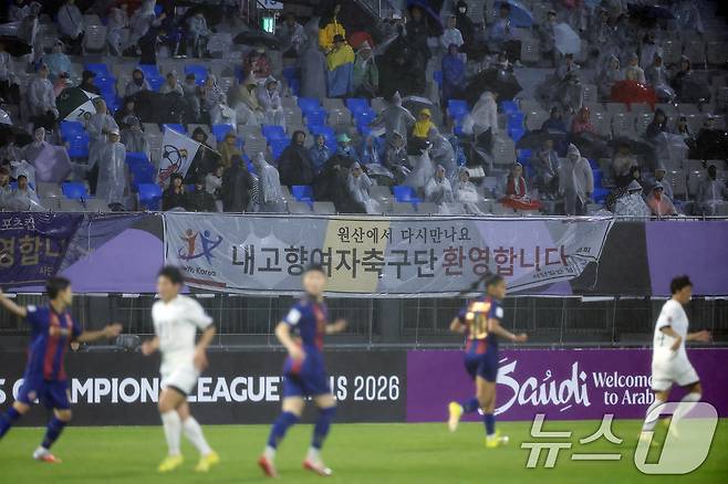 20일 오후 경기도 수원시 장안구 경수대로 수원종합운동장에서 열린 2025-2026 아시아축구연맹(AFC) 여자 챔피언스리그(AWCL) 4강 수원FC 위민과 북한 내고향여자축구단의 경기에서 공동응원단 등이 '내고향여자축구단 환영합니다. 원산에서 다시만나요' 플래카드를 내걸고 '내고향여자축구단' 엠블럼 깃발을 흔들고 있다. 내고향축구단은 북한의 소비재 기업인 '내고향'이 지난 2013년 창단, 국제축구연맹(FIFA) 랭킹 10위에 오를 정도로 세계에서 실력을 인정받고 있는 강팀이다. 2026.5.20 ⓒ 뉴스1 박정호 기자