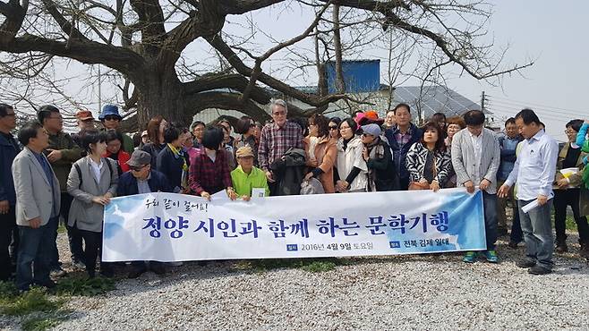 2016년 시집 ‘헛짚으며 헛디디며’ 출간 기념 문학기행 참가자들이 고인의 고향 마을 은행나무 앞에서 고인(가운데)과 함께 사진을 찍고 있다. 이병초 시인 제공