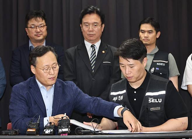 20일 경기 수원시 장안구 경기고용노동청에서 열린 삼성전자 임금협상을 마친 후 여명구 삼성전자 DS(디바이스솔루션·반도체 사업 담당) 피플팀장과 최승호 삼성그룹 초기업노동조합 삼성전자지부 위원장이 잠정 합의안에 서명을 하고 있다. (사진=뉴스1)
