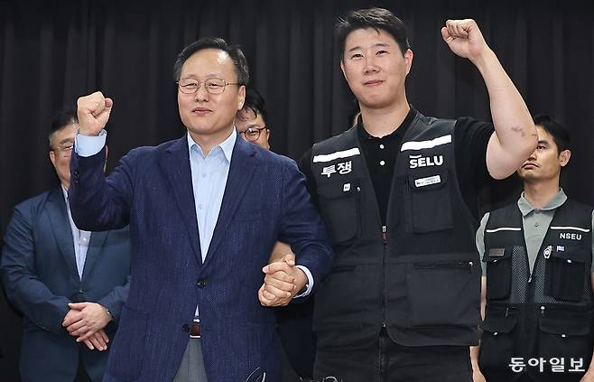 20일 경기 수원시 영통구 중부지방고용노동청 경기지청에서 열린 삼성전자 노사 추가 교섭에서 노사가 잠정합의안을 마련한 뒤 여명구 삼성전자 DS부문 피플팀장(오른쪽)과 최승호 삼성전자 초기업노조 삼성전자지부 위원장이 손을 잡고 파이팅을 외치고 있다. 수원=양회성 기자 yohan@donga.com
