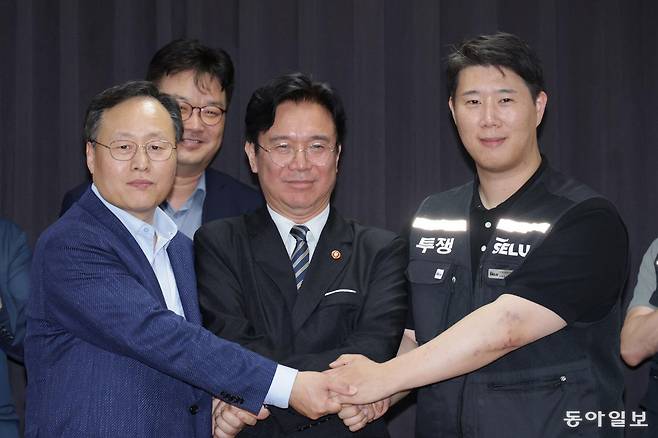 20일 경기도 수원시 장안구 경기고용노동청에서 열린 삼성전자 임금협상을 마친 후 여명구 삼성전자 DS(디바이스솔루션·반도체 사업 담당) 피플팀장과 김영훈 고용노동부 장관, 최승호 삼성그룹 초기업노동조합 삼성전자지부 위원장이 잠정 합의한에 서명한 후 손을 맞잡고 있다. 수원=양회성 기자 yohan@donga.com