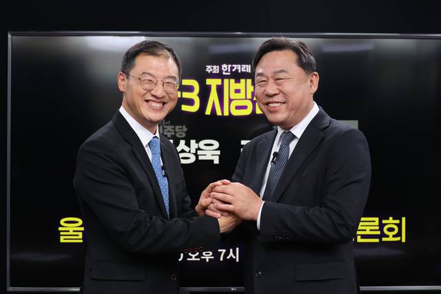 6·3 지방선거 울산시장 후보 단일화에 합의한 더불어민주당 김상욱 후보(왼쪽)와 진보당 김종훈 후보가 20일 서울 마포구 한겨레 신문사에서 열린 단일화 토론회에서 손을 맞잡고 있다. 연합뉴스