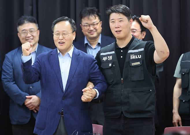 20일 경기도 수원시 장안구 경기고용노동청에서 열린 삼성전자 임금협상을 마친 후 여명구 삼성전자 디바이스솔루션(DS) 피플팀장(부사장)과 최승호 삼성그룹 초기업노동조합 삼성전자지부(초기업노조) 위원장이 잠정 합의안에 서명한 후 파이팅을 외치고 있다. 사진=연합뉴스