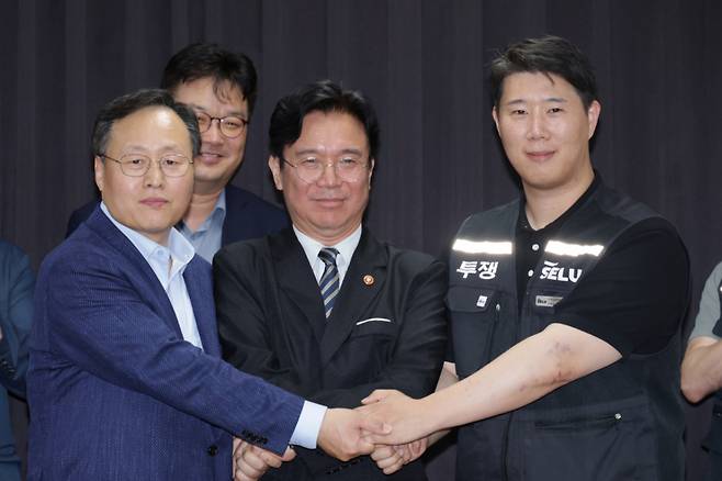 (수원=뉴스1) 김영운 기자 = 20일 경기도 수원시 장안구 경기고용노동청에서 열린 삼성전자 임금협상을 마친 후 여명구 삼성전자 DS(디바이스솔루션·반도체 사업 담당) 피플팀장과 김영훈 고용노동부 장관, 최승호 삼성그룹 초기업노동조합 삼성전자지부 위원장이 잠정 합의한에 서명한 후 손을 맞잡고 있다. (공동취재) 2026.5.20/뉴스1 Copyright (C) 뉴스1. All rights reserved. 무단 전재 및 재배포, AI학습 이용 금지. /사진=(수원=뉴스1) 김영운 기자