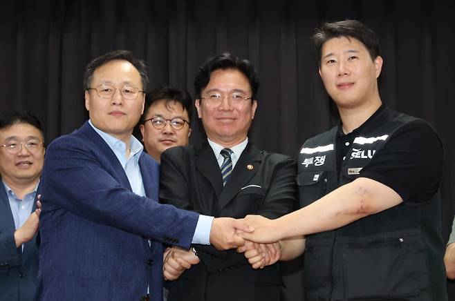 손 맞잡은 노사정 - 20일 경기 수원시 장안구 경기고용노동청에서 열린 삼성전자 임금협상을 마친 후 여명구 삼성전자 DS(디바이스솔루션·반도체 사업 담당) 피플팀장(왼쪽부터)과 김영훈 고용노동부 장관, 최승호 삼성그룹 초기업노동조합 삼성전자지부 위원장이 잠정 합의한에 서명한 후 손을 맞잡고 있다. (공동취재) 2026.05.20. 뉴시스