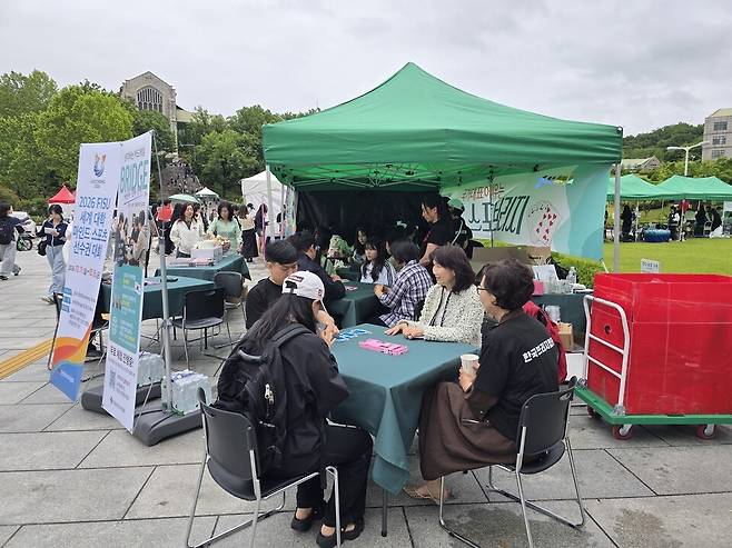 21일 서울 서대문구 이화여대 '해방이화' 축제 현장에 마련된 브리지 체험 부스에서 학생들이 국가대표 선수들의 설명을 들으며 브리지를 배우고 있다. 한국브리지협회 제공