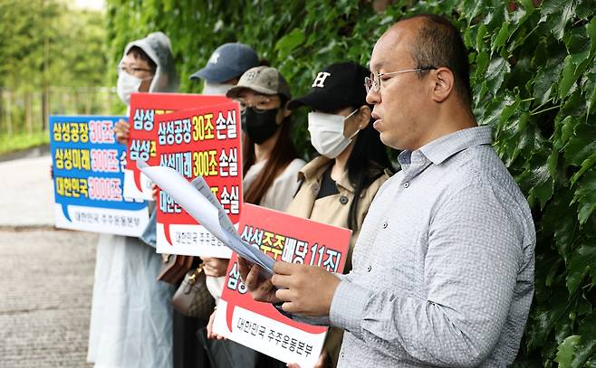 21일 서울 용산구 이재용 삼성전자 회장 자택 앞에서 열린 삼성전자 주주 총결집 집회에서 삼성전자 주주단체인 '대한민국 주주운동본부' 관계자들이 손팻말을 들고 있다. 연합뉴스