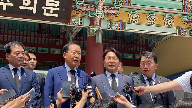 2024년 5월 17일 홍준표(앞줄 왼쪽) 당시 대구시장이 5·18 민주화운동 기념일을 하루 앞두고 광주 북구 운정동 국립 5·18민주묘지를 참배한 뒤 "5·18 유공자 명단을 공개해야 한다"고 주장하고 있다. 광주=김진영 기자