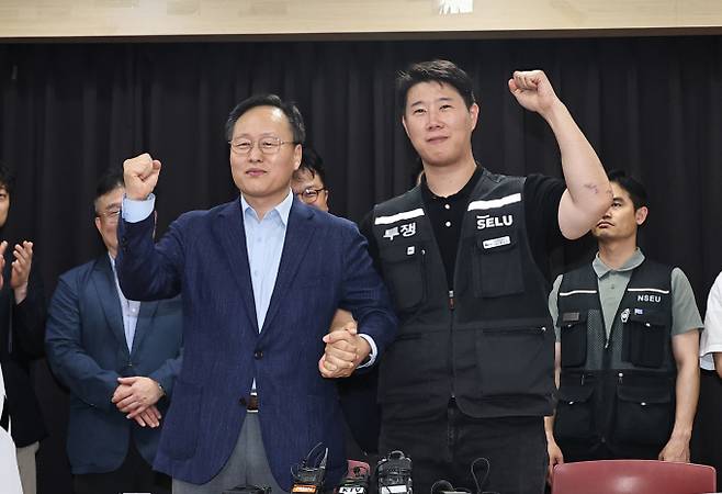 5월20일 경기 수원시 장안구 경기고용노동청에서 열린 삼성전자 임금협상을 마친 후 여명구 삼성전자 DS(디바이스솔루션·반도체 사업 담당) 피플팀장과 최승호 삼성그룹 초기업노동조합 삼성전자지부 위원장이 잠정 합의안에 서명한 후 파이팅을 외치고 있다. / 사진=공동취재