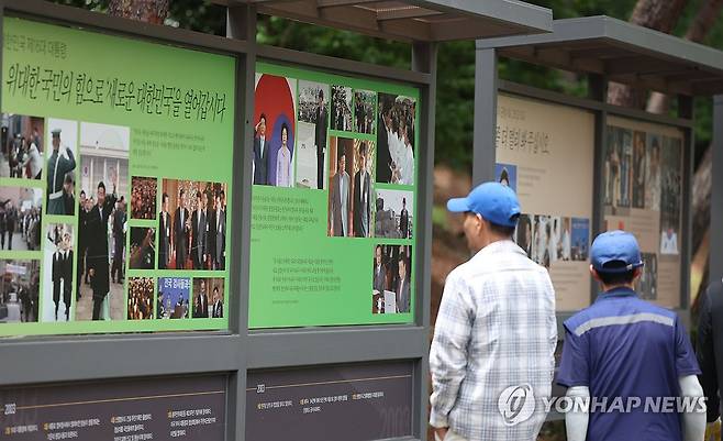 17주기 추도식 앞둔 봉하마을 (김해=연합뉴스) 김동민 기자 = 고 노무현 전 대통령 서거 17주기 추도식을 하루 앞둔 22일 오후 경남 김해시 진영읍 봉하마을을 찾은 시민이 노 전 대통령 사진과 업적 등이 부착된 게시판을 바라보고 있다. 2026.5.22 image@yna.co.kr