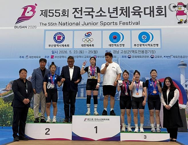 제55회 전국소년체육대회 역도 여자 15세 이하부 55㎏급에서 3관왕에 오른 노지은(안산 선부중)과 조성현 코치가 시상대 맨 위에서 메달을 걸고 기념사진을 찍고 있다.