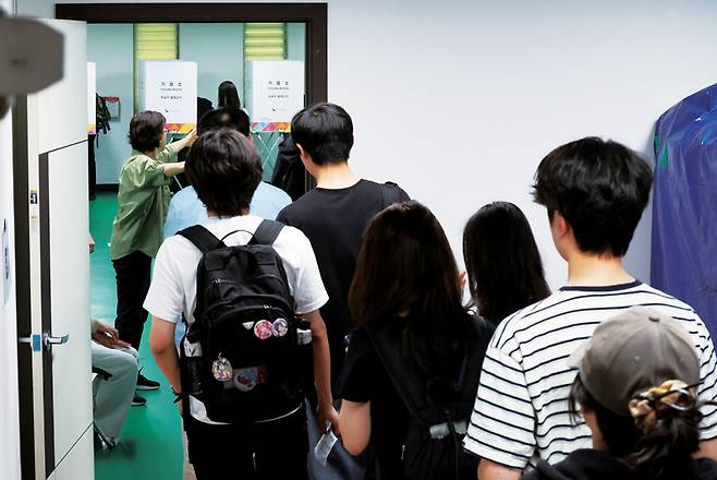 21대 대통령선거 사전투표 둘째 날인 2025년 5월30일 서울 관악구 낙성대동주민센터에 마련된 투표소에서 청년들이 투표하기 위해 줄을 서고 있다.