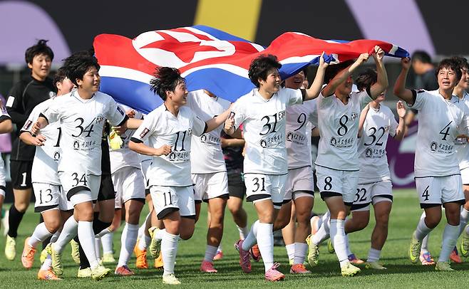 ▲ 23일 수원 장안구 수원종합운동장에서 열린 아시아축구연맹(AFC) 여자 챔피언스리그(AWCL) 결승 내고향여자축구단과 도쿄 베르디 벨레자의 경기. 우승한 내고향 선수들이 인공기를 들고 달리고 있다. ⓒ연합뉴스
