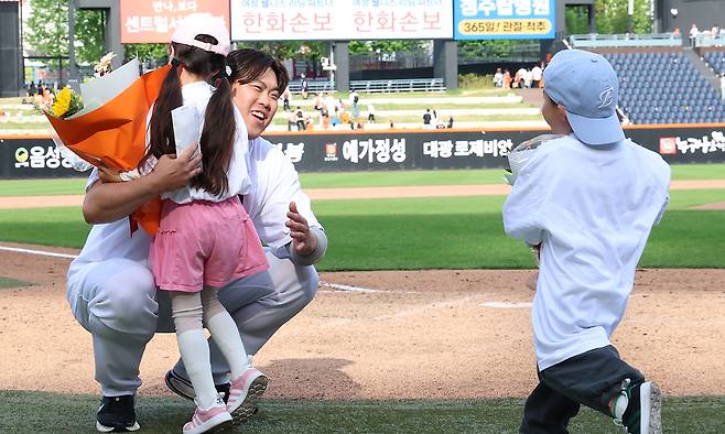 이 기쁨을 딸·아들과 함께… 프로야구 한화의 류현진이 24일 대전 한화생명볼파크에서 열린 2026 KBO리그 두산과의 홈경기에서 한·미 통산 200승을 달성한 뒤 딸 혜성양과 아들 준상군의 축하를 받고 있다. 대전=뉴스1