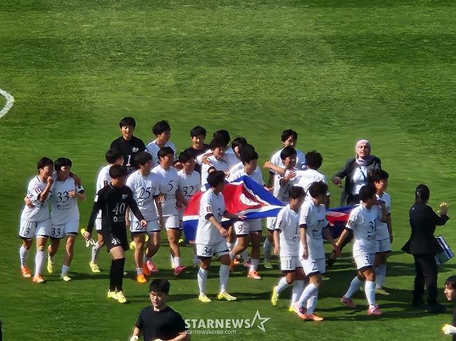내고향여자축구단(왼쪽 아래)이 인공기를 들고 뛰어가자 공동응원단(오른쪽)이 환호하고 있다. /사진=박건도 기자