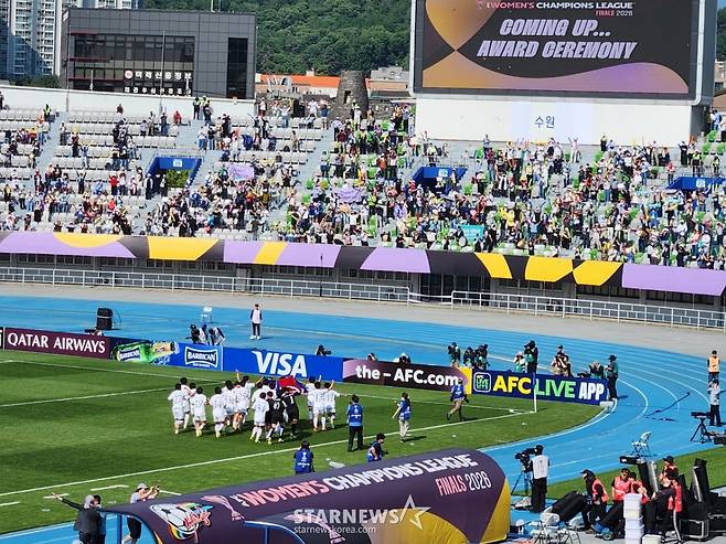 내고향여자축구단(왼쪽 아래)이 인공기를 들고 뛰어가자 공동응원단(오른쪽)이 환호하고 있다. /사진=박건도 기자