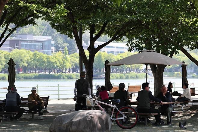 대구 지역의 낮 최고 기온이 34.7℃를 기록하며 한여름같이 무더운 날씨를 보인 지난 18일 수성구 수성못 나무 그늘에서 시민들이 더위를 식히고 있다. /이용선기자