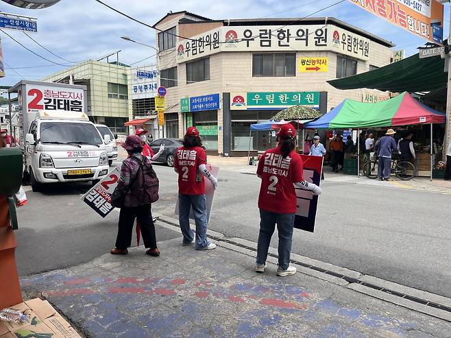 26일 공주 산성시장에서 김태흠 국민의힘 충남지사 후보 선거운동원들이 피켓을 들고 지지를 호소하고 있다. 우수아 기자