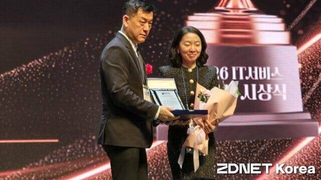 이민정 세종사이버대학교 교수(오른쪽)가 박승범 한국IT서비스학회장에게서 IT서비스 우수연구인상을 받고 있다.