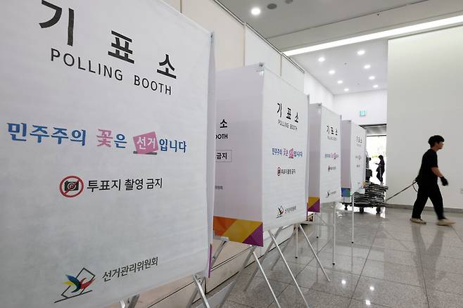 제9회 전국동시지방선거 사전투표 개시를 하루 앞둔 28일 광주 북구 전남대학교 컨벤션홀에서 선관위 관계자가 사전투표소를 설치하고 있다. 연합뉴스