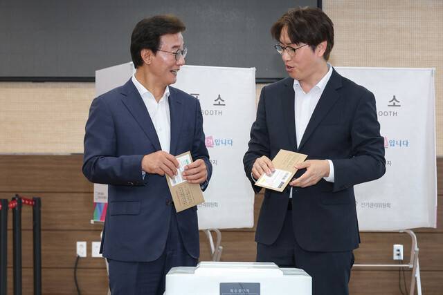 전재수 더불어민주당 부산시장 후보(왼쪽)와 하정우 부산 북갑 국회의원 보궐선거 후보가 29일 부산 북구 덕천2동 행정복지센터에 마련된 사전투표소에서 투표를 하고 있다. 연합뉴스