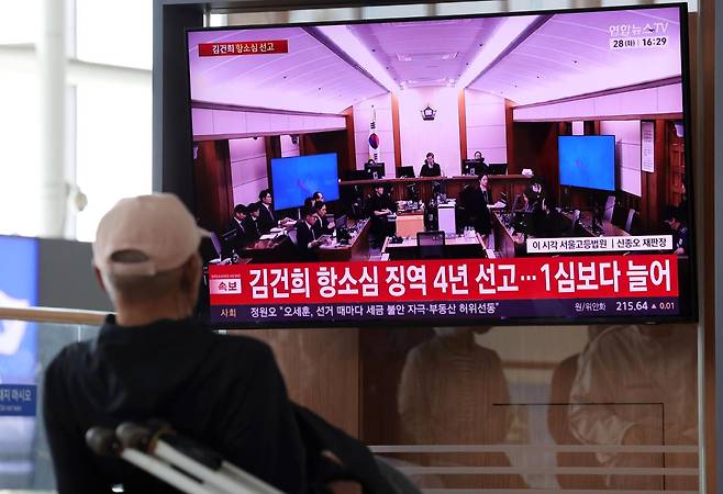 지난달 28일 서울 중구 서울역 대합실에서 시민들이 김건희 여사의 도이치모터스 주가조작, 무상여론조사 수수, 통일교 금품 수수 혐의 관련 항소심 선고 생중계를 지켜보고 있다. 뉴시스