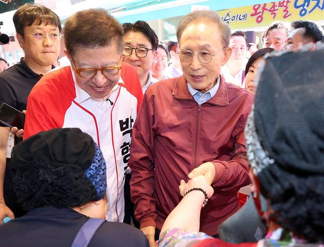 이명박 전 대통령이 31일 부산 해운대구 해운대시장을 방문, 상인들과 인사하며 박형준 국민의힘 부산시장 후보의 지지를 호소하고 있다. 뉴시스
