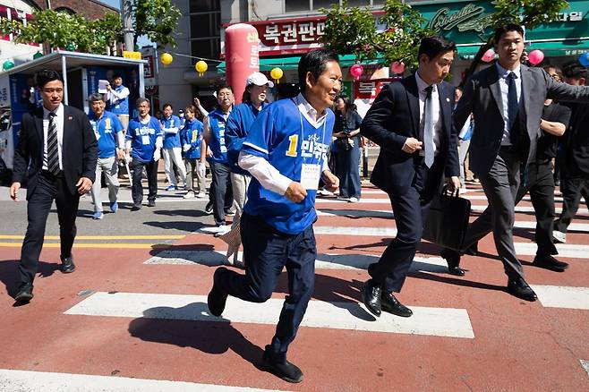 정청래 더불어민주당 대표가 31일 충북 영동군 영동전통시장 앞에서 이수동 영동군수 후보 지원유세를 마친 후 시민들과 인사하기 위해 뛰어가고 있다. 뉴스1