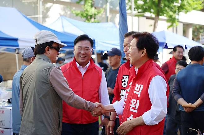 박완수 국민의힘 경남지사 후보가 31일 오전 경남 창원시 마산합포구 번개시장을 찾아 시민과 악수하며 지지를 호소하고 있다. 사진 박완수 후보 캠프