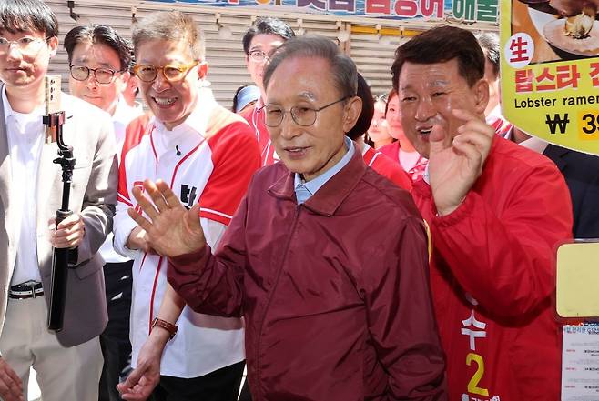 이명박 전 대통령이 31일 부산 해운대구의 한 족발 식당을 방문, 국민의힘 박형준 부산시장 후보의 지지를 호소하며 상인과 인사하고 있다. 연합뉴스