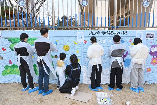 경북도교육청 소속 발달장애 청년 미술단 '온그림' 단원들이 해마루중학교의 낡은 담벼락을 예쁜 그림으로 채워 넣는 벽화 봉사활동에 한창이다. 경북도교육청 제공