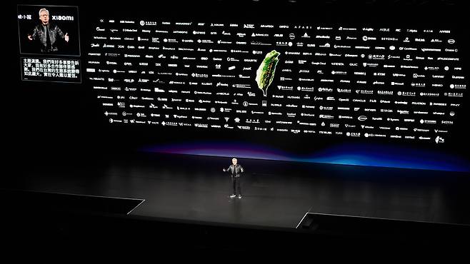 젠슨 황 엔비디아 CEO가 2026년 컴퓨텍스 키노트에서 대만 지도를 중심으로 수백 개 협력사 로고를 띄우며 AI 생태계의 규모를 강조하고 있다. GPU·CPU·네트워크·클라우드·소프트웨어 기업이 하나의 공급망으로 연결된 구조를 제시했다. / 이상헌 기자
