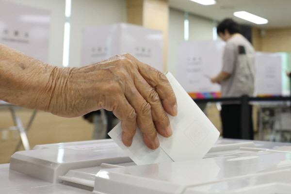제9회 전국동시지방선거 사전투표 첫날인 29일 세종시 북세종통합행정복지센터에 마련된 투표소에서 한 시민이 투표함에 기표를 마친 투표용지를 넣고 있다. 연합뉴스