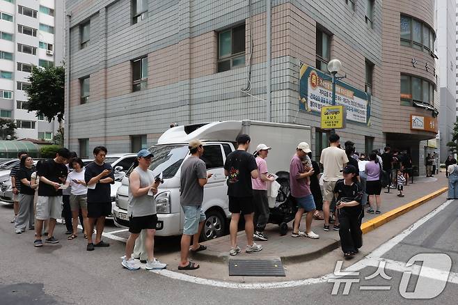 제9회 전국동시지방선거일인 3일 서울시 송파구의 가락쌍용 아파트 단지 내에 마련된 가락2동 제3, 7투표소를 찾은 유권자들이 투표용지가 부족한 상황이 해소될 때까지 길게 줄지어 대기하고 있다. 2026.6.3 ⓒ 뉴스1 김진환 기자