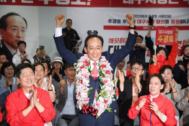 국민의힘 추경호 대구시장 후보가 당선이 유력시되면서 4일 오전 대구 범어네거리 선거사무소에서 축하 꽃다발을 목에 걸고 있다. 연합뉴스
