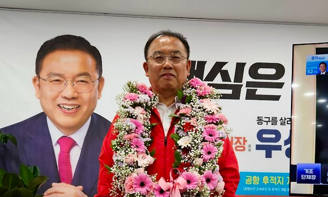 ▲ 우성진 대구 동구청장 당선인이 4일 선거사무소에서 축하 꽃목걸이를 걸고 지지자들에게 인사하고 있다. 우성진 캠프 제공