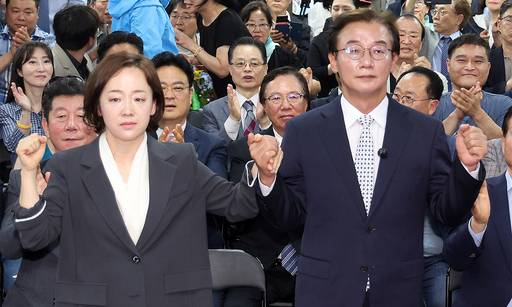 전재수 부산시장 당선인(오른쪽)이 4일 당선이 확정된 이후 배우자 최혜진 씨와 손을 잡아 올리고 있다./공동취재