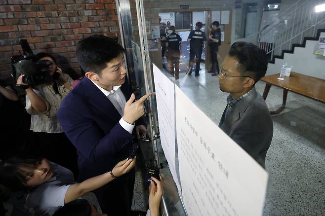 제9회 전국동시지방선거 및 국회의원 재·보궐선거 본투표일인 3일 투표용지 부족으로 투표 시간이 오후 10시까지 연장된 서울 송파구 잠실7동 제2투표소를 찾은 김재섭 국민의힘 의원이 선관위 관계자와 닫힌 문을 사이에 두고 대화하고 있다./뉴스1